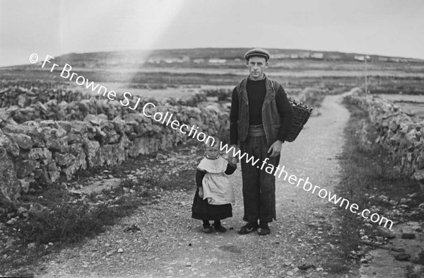 MAN WITH CHILD ON ROAD. FATHER AND SON ON INISHEER